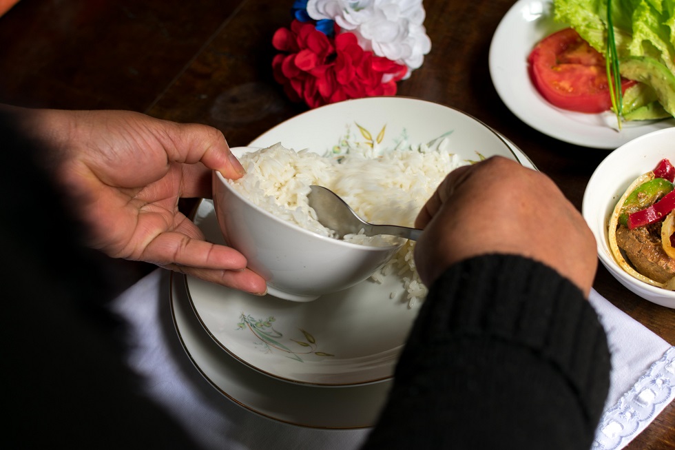 Mujer tiras de repollo ensalada de col cortador manual en la tabla